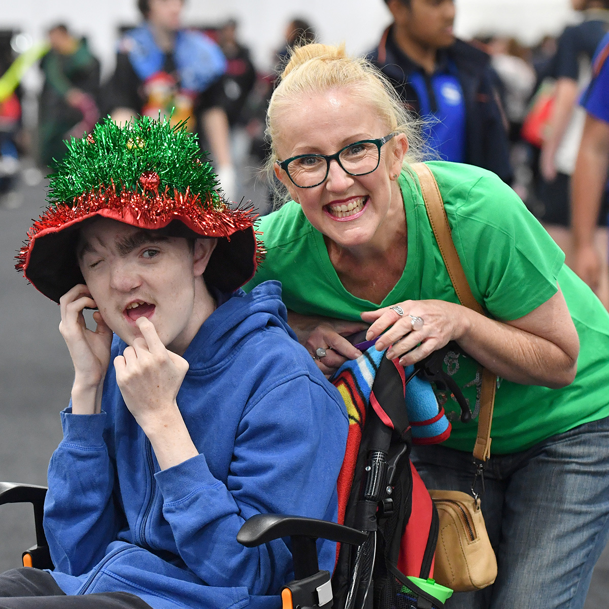 happy child sitting in wheel chair smiling at Variety kids Christmas party
